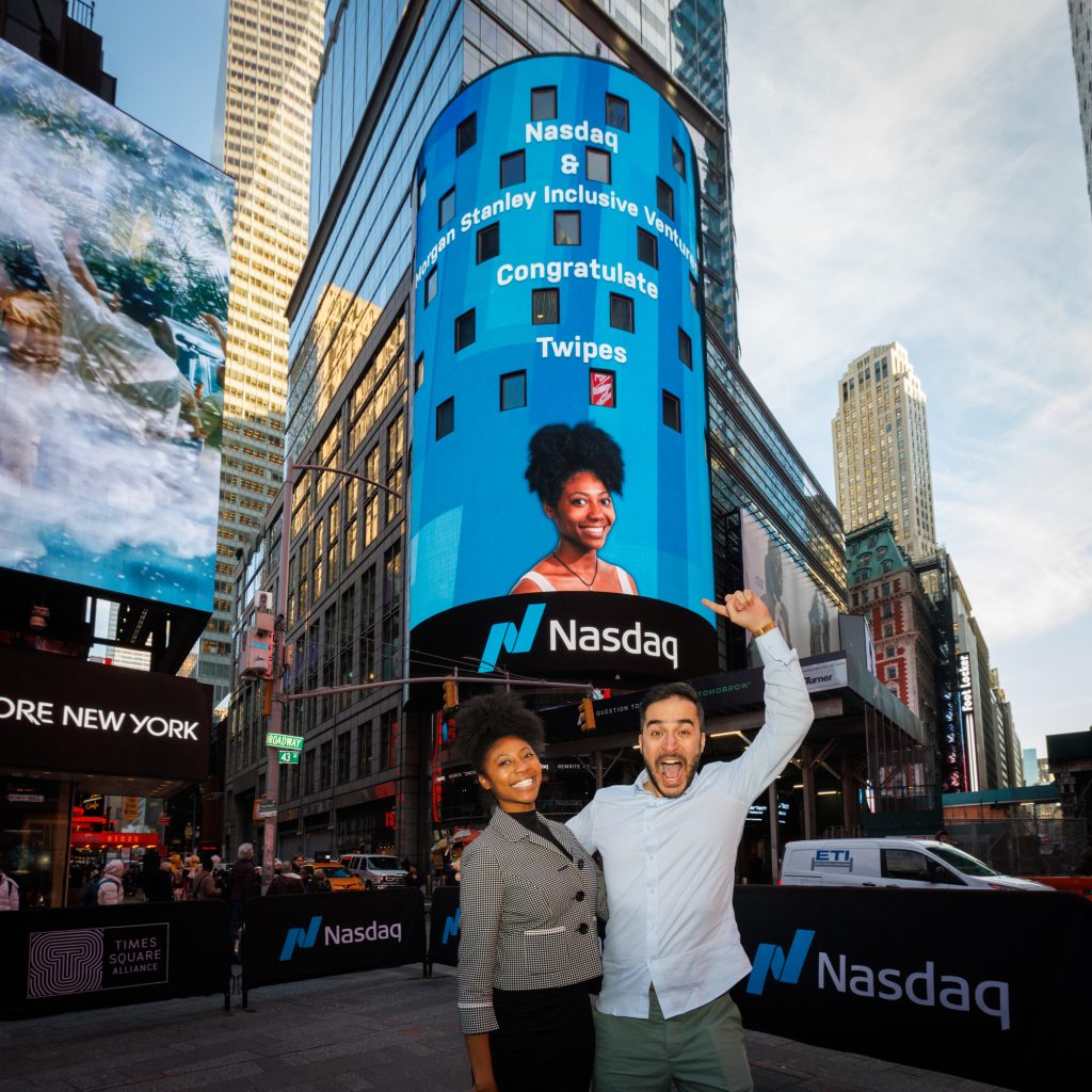 Elle and Al in front of the Nasdaq sign in Times Square