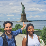 A photo of Twipes cofounders Al and Elle in front of the Statue of Liberty in New York City